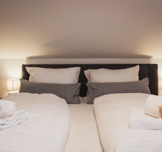 Schlafzimmer mit Boxspringbett - Family Aparts Steinadler