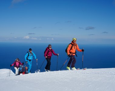 Skitourengruppe im aufstieg, meer im hintergrund