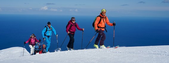 Skitourengruppe im aufstieg, meer im hintergrund
