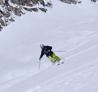skifahrer in der Kurve, grüne Hose, schwarze Jacke