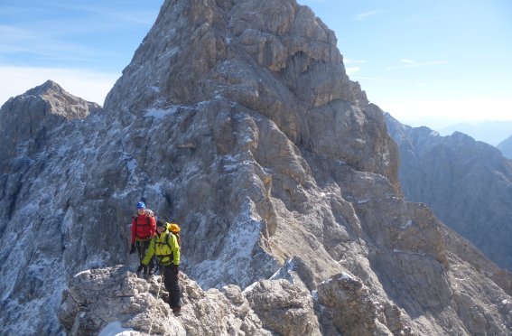 2 Kletterer am Felsgrat mit grüner und roter Jacke