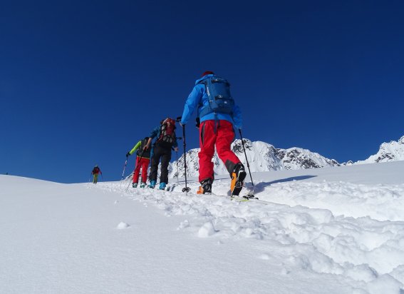 Skitourengruppe von hinten im Aufstieg