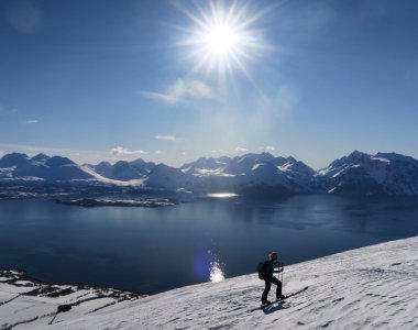 sonne, bergkette, fjord, skitourengeher im vordergrund