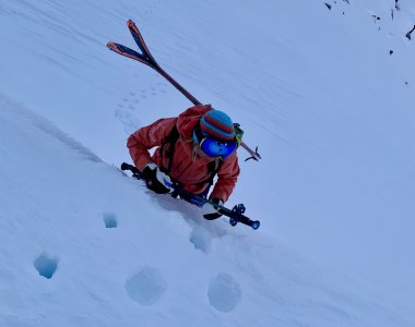 skitourengeher, ski am ruecken, steile spur im schnee