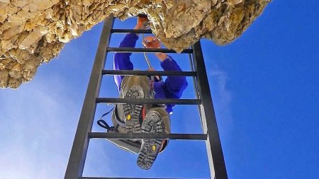 kletterer auf Leiter-klettersteig-blauer Himmel