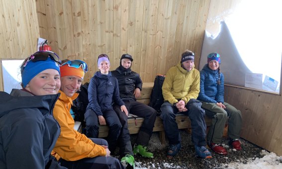 Skitouren in den Lyngen Alps: Rast einer geführten Gruppe in einer Bivakschachtel beim Aufstieg, Schutz vor Wind und Wetter im arktischen Winter