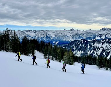 skitourengeher im aufstieg, bergpanorama, schichtbewoelkung