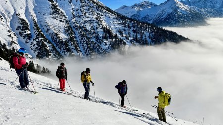 mehrere skifahrer, wolkendecke im tal, berge
