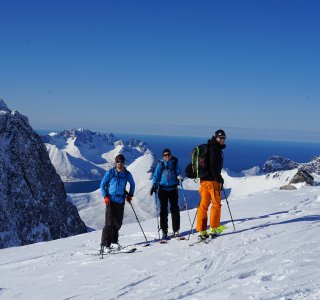 3 skifahrer, blauerhimmel, berge schnee