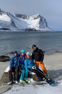 skifahrergruppe am meer, sandstrand, weiße berge