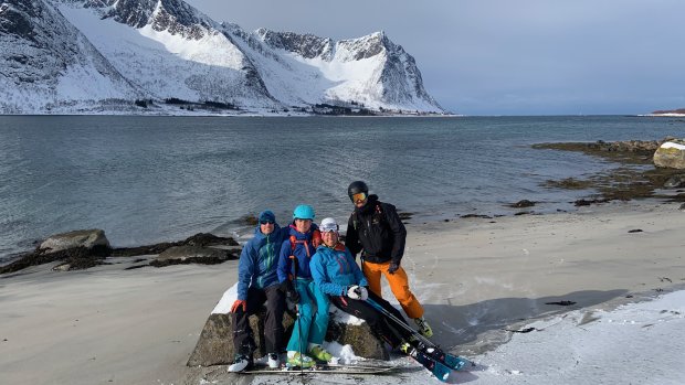 skifahrergruppe am meer, sandstrand, weiße berge
