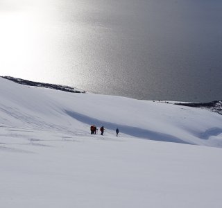 skifahrergruppe im gegenlicht vor dem meer