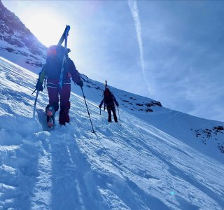 skitourengeher, ski am Rucksack, tiefschnee, sonne