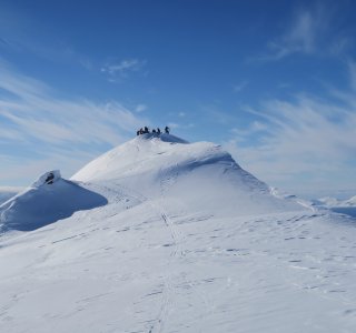 runde bergspitze mit mehreren personen, schnee, blauer himmel mit wolken