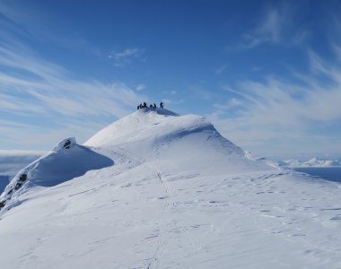 runde bergspitze mit mehreren personen, schnee, blauer himmel mit wolken