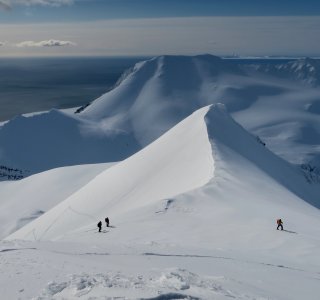 schneegrat, 3 personen mit toureski im aufstieg, fjordlandschaft