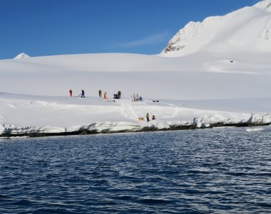 skitourengruppe am fjordufer, wasser im vordergrund