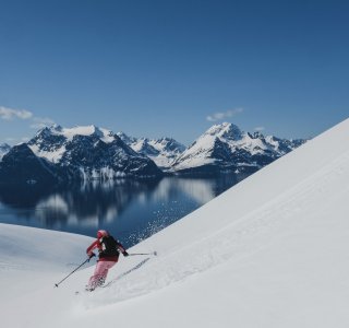 skifahrer in der abfahrt vor Fjord