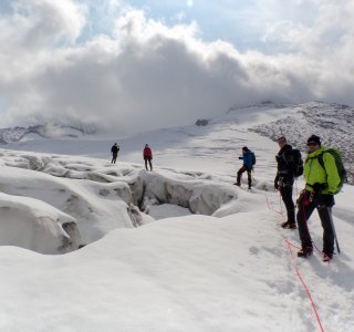 gletscherspalten, wolken, bergsteigergruppe am seil