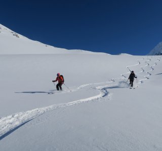 2 skifahrer bei der abfahrt im tiefschnee