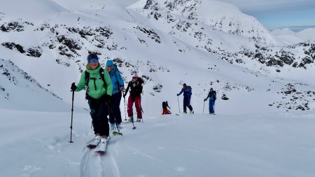 skitourengruppe im aufstieg, bedeckter himmel, grüne jacke
