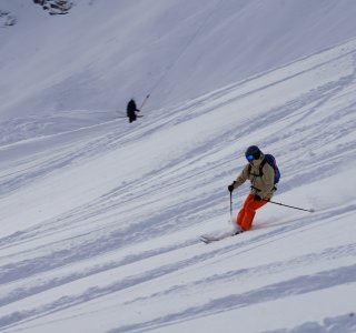 skifahrer mit roterhose bei der abfahrt