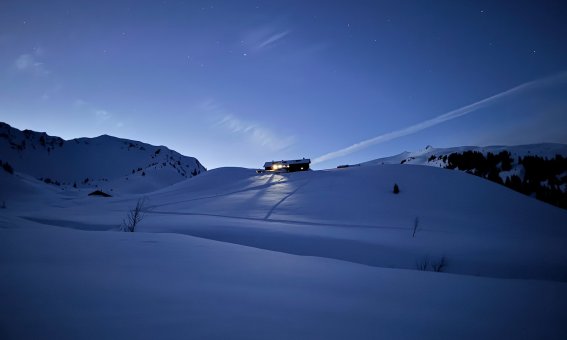 schwarzwasserhütte im letzten tageslicht, winter, beleuchtete fenster,