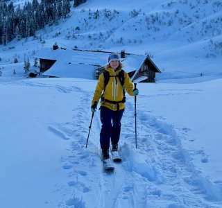 skitourengeherin mit gelber jacke