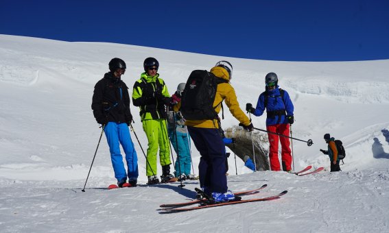 skigruppe mit skilehrer am pistenrand