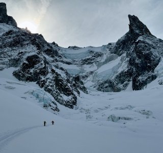 felsspitze, gletscherbrüche, 2 skitourengeher, trüber himmel