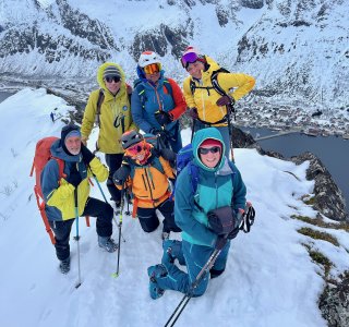 skitourengruppe auf schmalem gipfel über dem meer, senja, gryllefjord