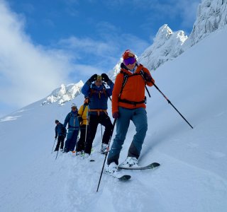 skitourengruppe bei der abfahrt, himmel, wolken, kleine felstürme, schnee