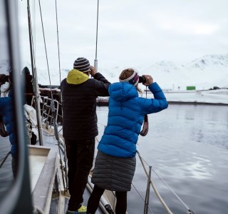 2 personen mit fernglas an der reeling