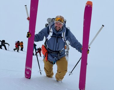 skitourengeher mit ski in der hand im aufstieg