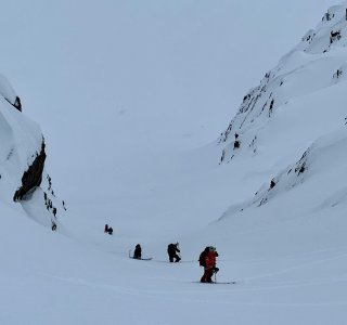 skitourengruppe im aufstieg durch steile rinne