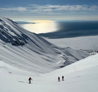 skitourengeher im aufstieg, meer mit sonne