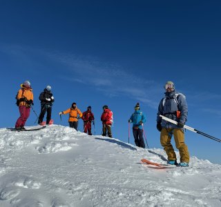 skitourengruppe auf dem gipfel, blauer himmel