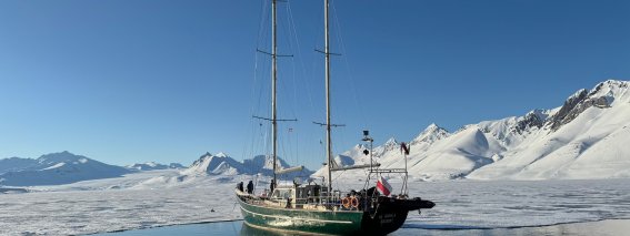 segelschiff, zweimaster auf spiegelglattem wasser, berge, schnee