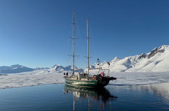 segelschiff, zweimaster auf spiegelglattem wasser, berge, schnee