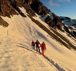 bergsteiger auf schneefeld im ersten morgenlicht