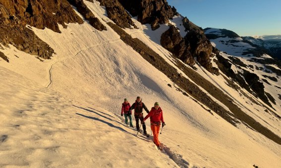 bergsteiger auf schneefeld im ersten morgenlicht