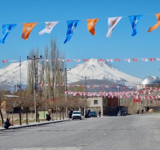 bunte wimpel vor bergmassif, moschee, strassenzene ostanatolien
