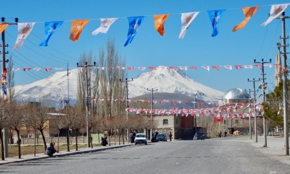 bunte wimpel vor bergmassif, moschee, strassenzene ostanatolien