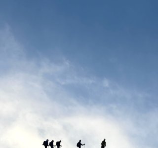 Skitour lyngenfjord, Svartfjellet, skifahrer im Gegenlicht vor Schneefahne