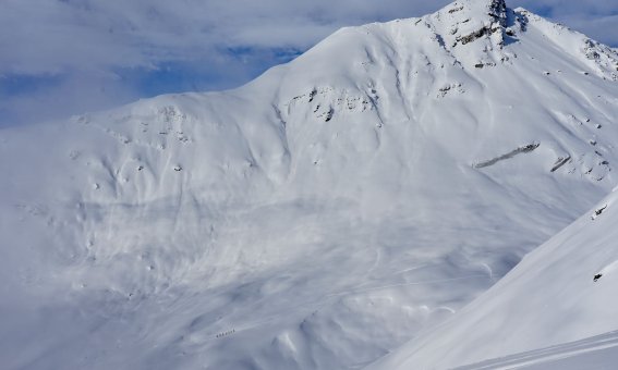 Georgien Skitour Svanetien  riesige Bergflanke mit Skitourengruppe