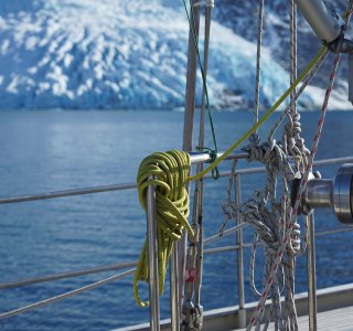 gletscher fließt ins meer, im vordergrund reling unserer yacht