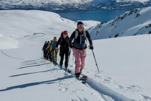 Seiland house, gruppe Aufstieg, fjord im hintergrund, vorne aufstiegsspur im tiefen schnee