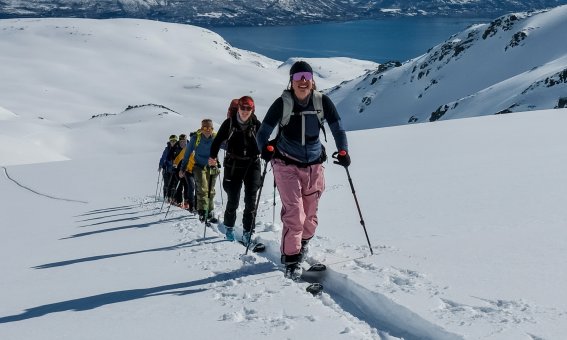 Seiland house, gruppe Aufstieg, fjord im hintergrund, vorne aufstiegsspur im tiefen schnee