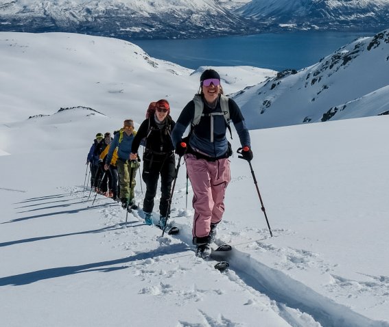 Seiland house, gruppe Aufstieg, fjord im hintergrund, vorne aufstiegsspur im tiefen schnee