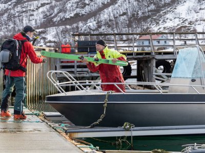 boot, zwei personen beim entladen der ski
